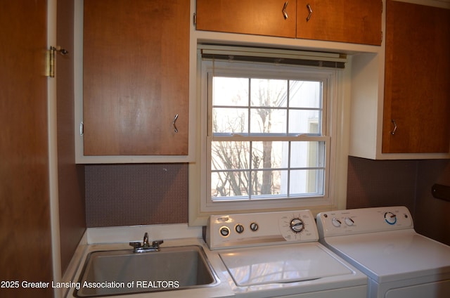 laundry area with cabinet space, washer and dryer, and a sink