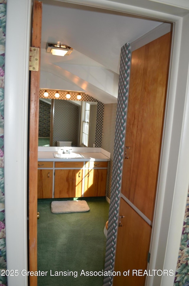 bathroom with wallpapered walls and vanity