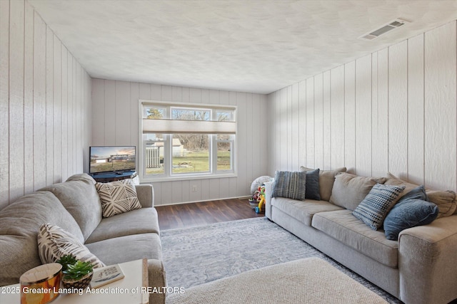 living area with wood finished floors and visible vents