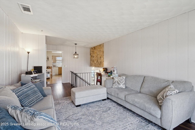 living area with visible vents and hardwood / wood-style floors