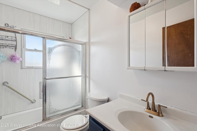 bathroom featuring combined bath / shower with glass door, toilet, and vanity