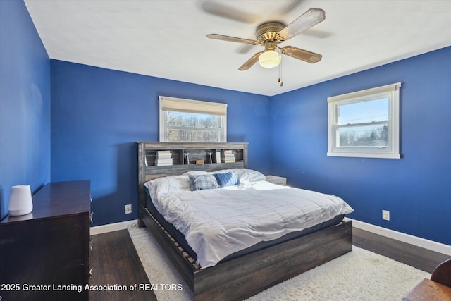 bedroom with multiple windows, baseboards, and wood finished floors