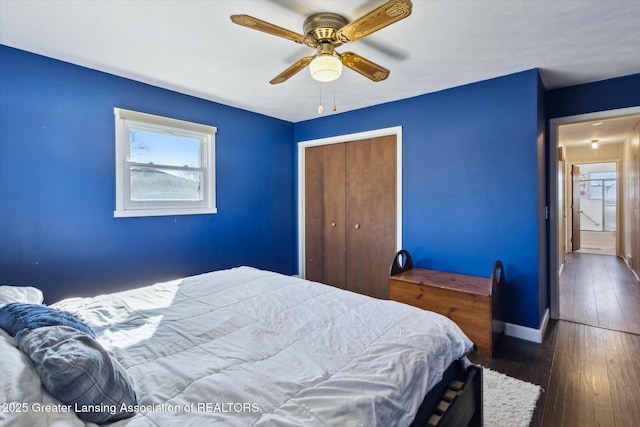 bedroom with a closet, ceiling fan, baseboards, and hardwood / wood-style flooring