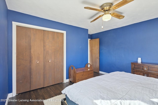 bedroom featuring a ceiling fan, wood finished floors, a closet, and baseboards