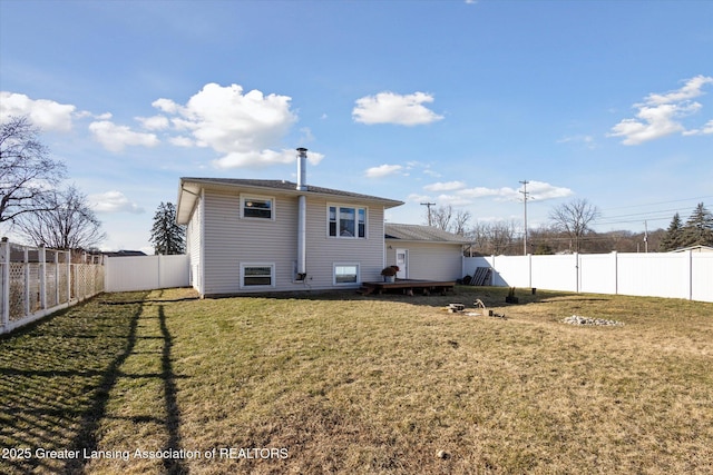 rear view of house with a yard, a wooden deck, and a fenced backyard