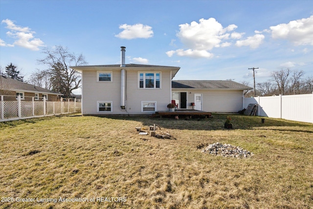 rear view of house featuring a yard, a fenced backyard, and a wooden deck