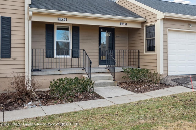 entrance to property with an attached garage, covered porch, and roof with shingles