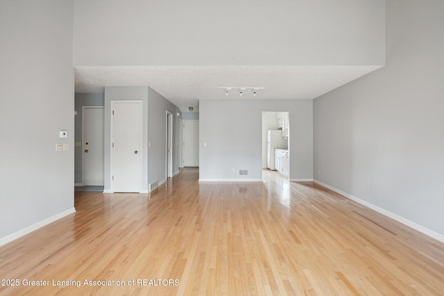 spare room with visible vents, light wood-type flooring, and baseboards