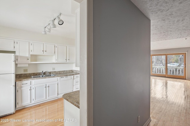 kitchen with a sink, light wood-style floors, white appliances, white cabinetry, and open shelves