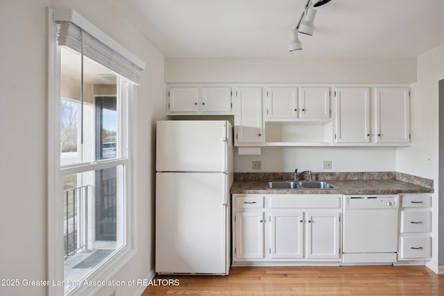 kitchen featuring a sink, light wood-type flooring, white appliances, and white cabinetry