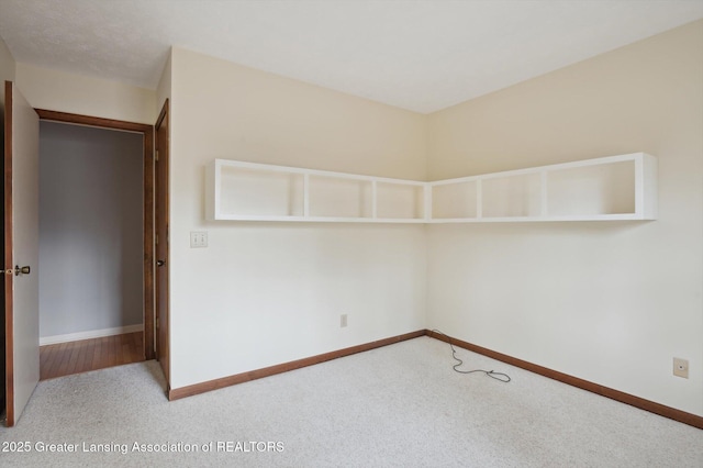 empty room featuring baseboards and carpet