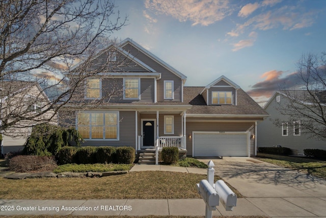 traditional home with a garage, a porch, and concrete driveway