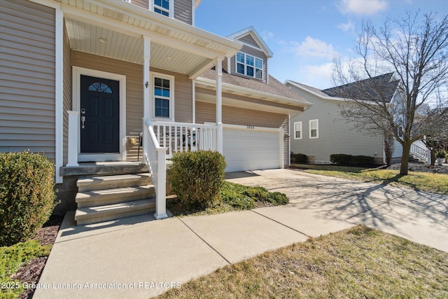 entrance to property with a porch, an attached garage, and driveway