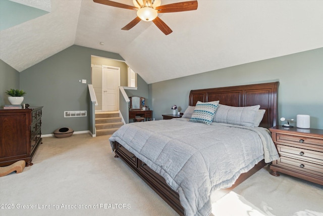 bedroom with a ceiling fan, baseboards, visible vents, vaulted ceiling, and light colored carpet