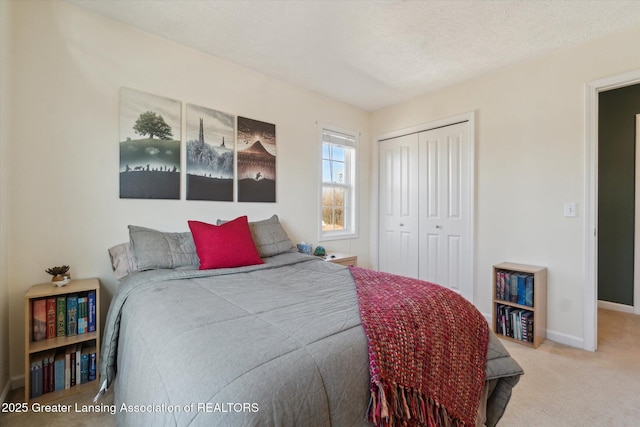 bedroom featuring a closet, carpet flooring, a textured ceiling, and baseboards