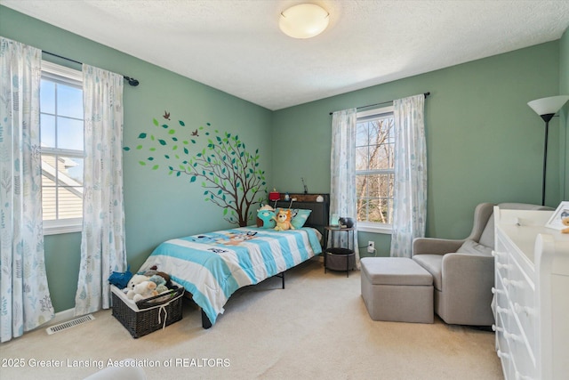 carpeted bedroom with visible vents and a textured ceiling