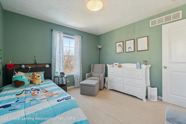 carpeted bedroom with baseboards, visible vents, and a textured ceiling