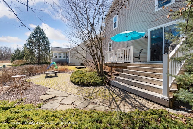 view of yard featuring a wooden deck, an outdoor fire pit, and a patio