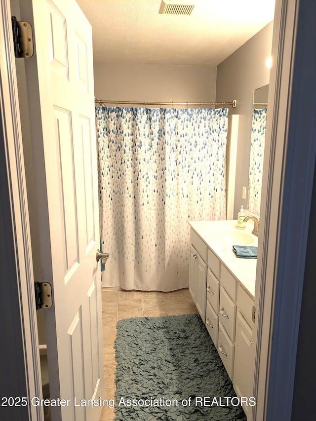 full bathroom featuring visible vents, a shower with curtain, vanity, and tile patterned flooring