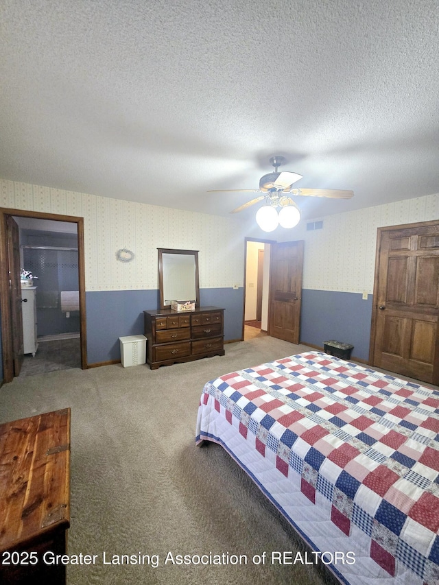 bedroom with visible vents, wallpapered walls, ceiling fan, carpet flooring, and a textured ceiling