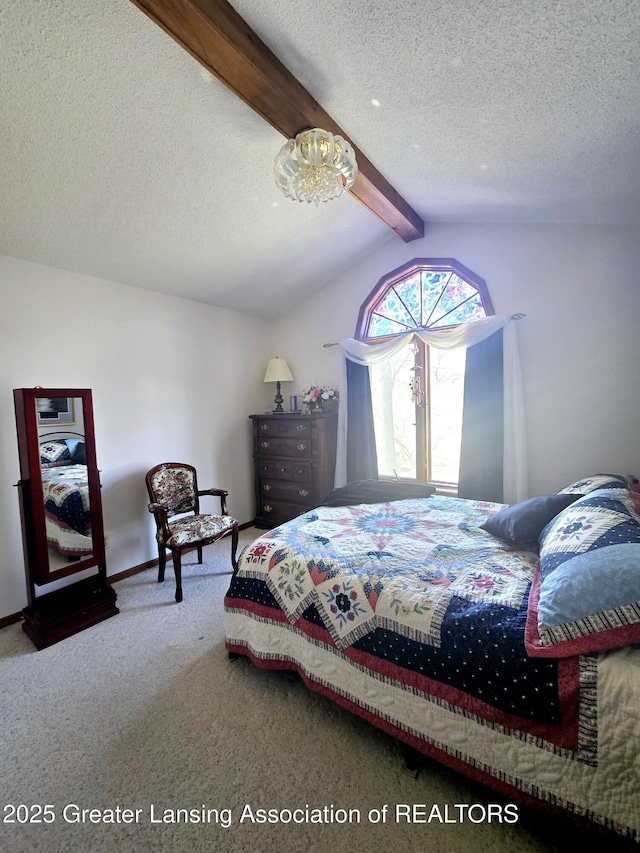 bedroom with lofted ceiling with beams, carpet, baseboards, and a textured ceiling