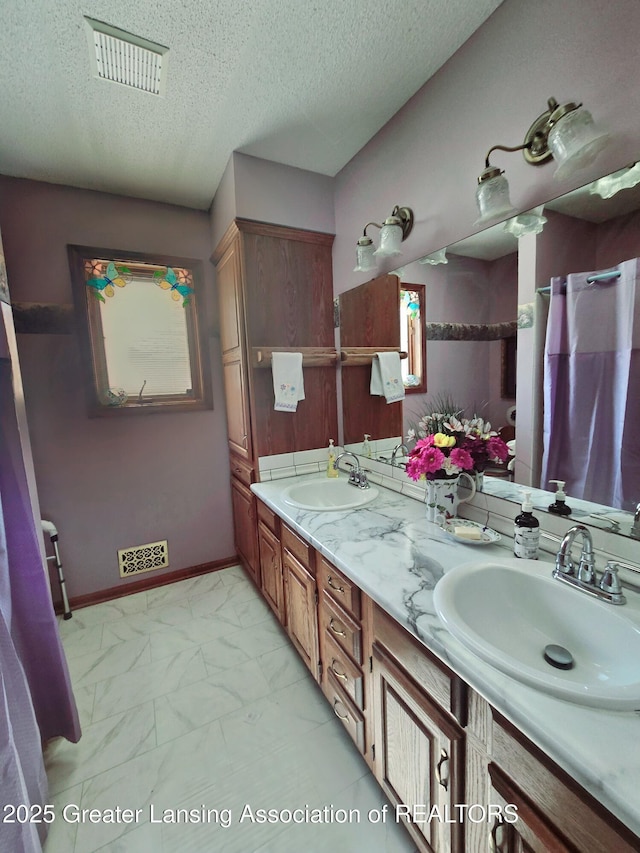 full bath featuring visible vents, marble finish floor, and a sink