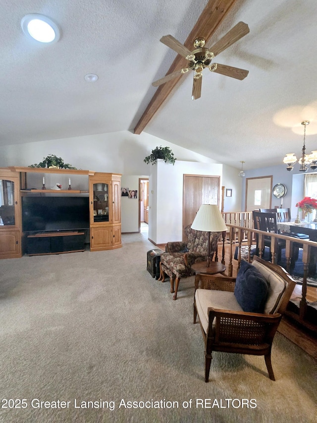 living area featuring ceiling fan with notable chandelier, lofted ceiling with beams, light colored carpet, and a textured ceiling