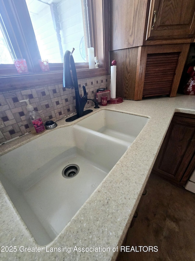 details with decorative backsplash, light countertops, and a sink