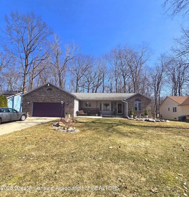 ranch-style home with driveway, a front lawn, covered porch, a garage, and brick siding