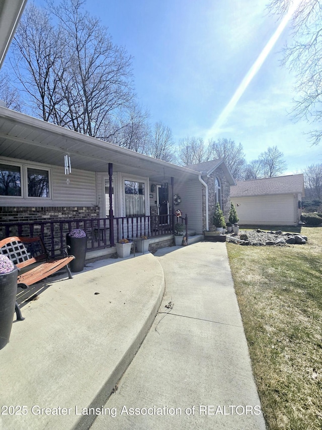 exterior space featuring an outdoor structure, a lawn, and covered porch