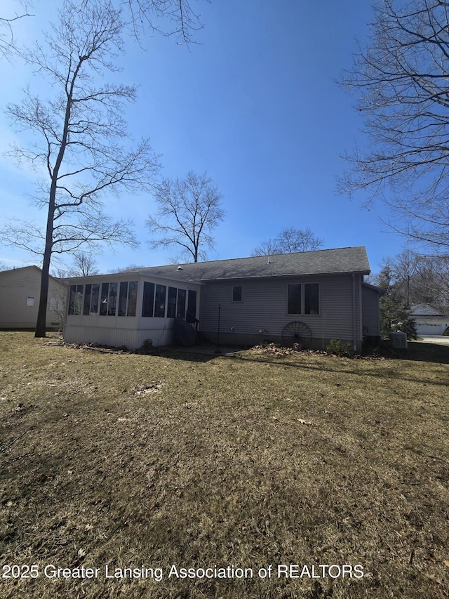 back of property featuring a lawn and a sunroom