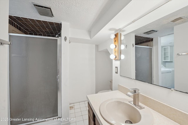 full bathroom featuring visible vents, a textured ceiling, a stall shower, and vanity