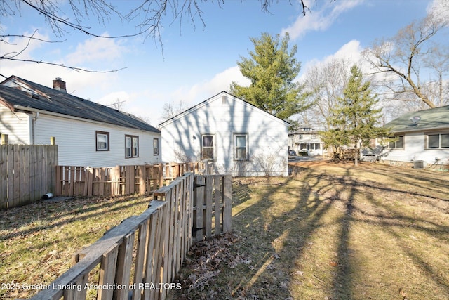 view of yard featuring central AC and fence