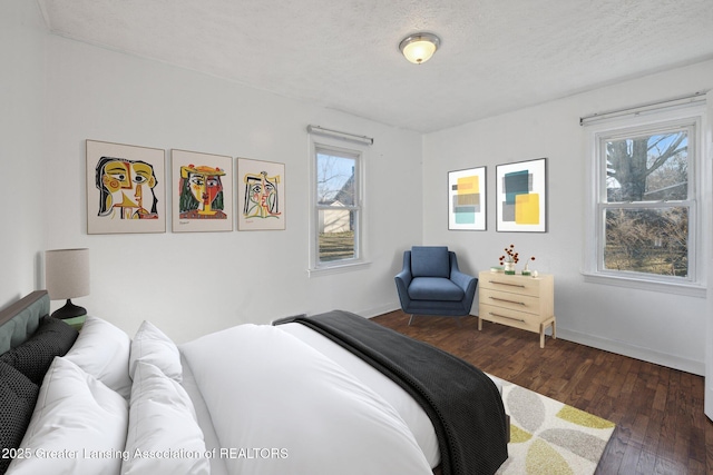 bedroom featuring multiple windows, a textured ceiling, and wood-type flooring