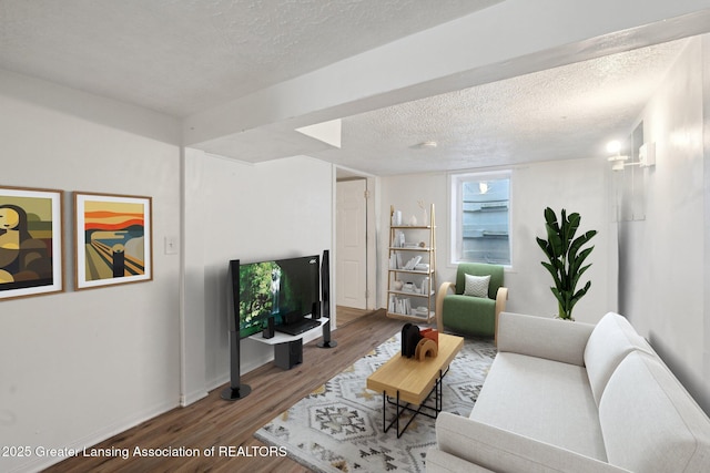 living room with baseboards, a textured ceiling, and wood finished floors