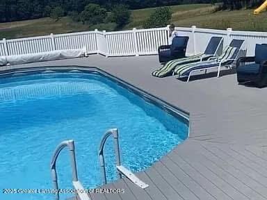 view of pool with a fenced in pool and a wooden deck