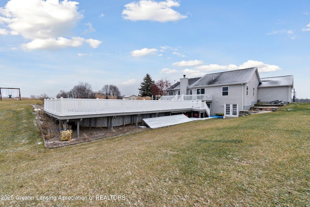 back of property featuring french doors, a lawn, and a wooden deck