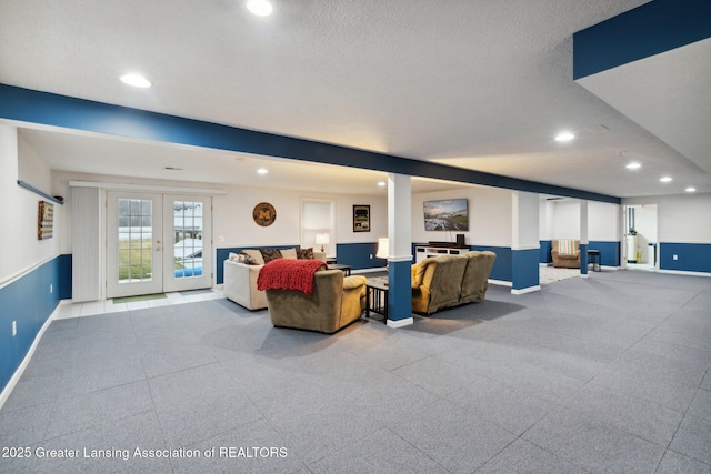 living room with recessed lighting, baseboards, french doors, and a textured ceiling