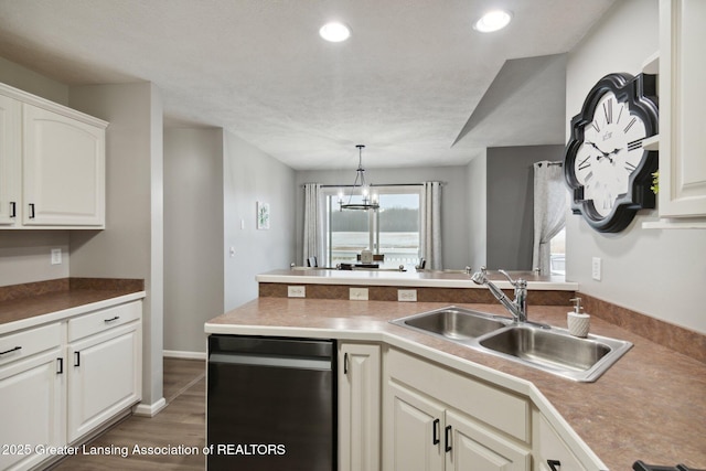 kitchen featuring dishwashing machine, an inviting chandelier, a peninsula, recessed lighting, and a sink