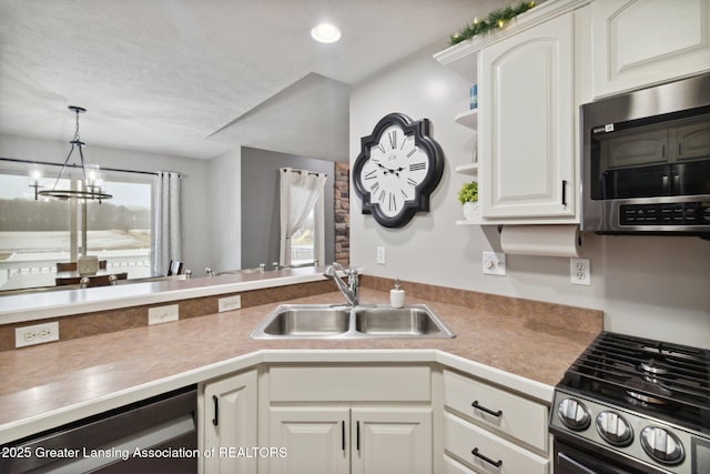 kitchen featuring a chandelier, appliances with stainless steel finishes, hanging light fixtures, white cabinets, and a sink