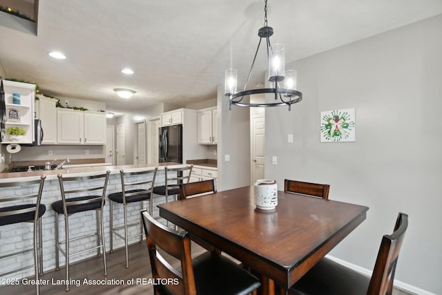 dining room with recessed lighting, dark wood-style flooring, and a chandelier