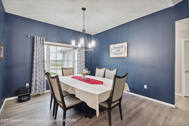 dining area with a notable chandelier, wood finished floors, and baseboards