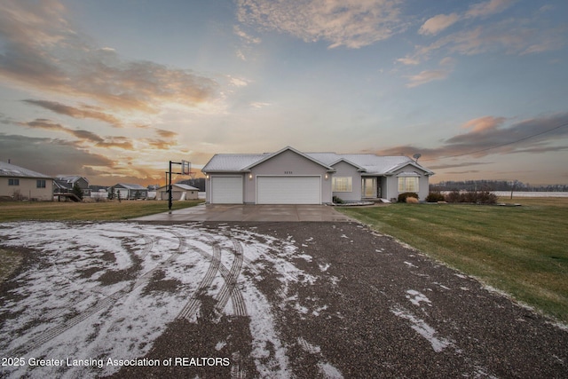 view of front of home with a garage, a lawn, and driveway