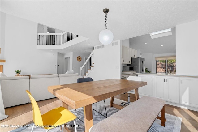 dining area featuring stairs, recessed lighting, visible vents, and light wood-type flooring