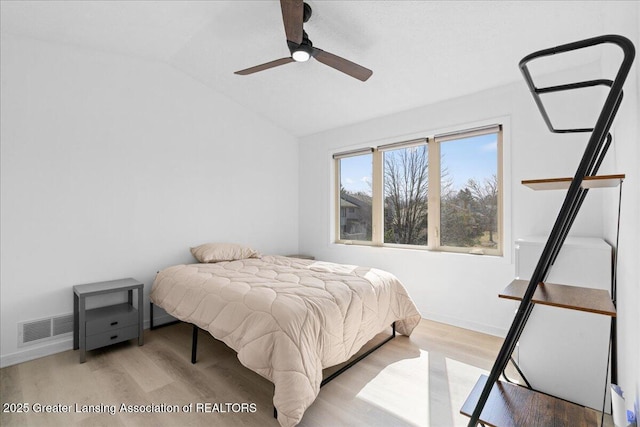 bedroom with visible vents, a ceiling fan, wood finished floors, baseboards, and lofted ceiling