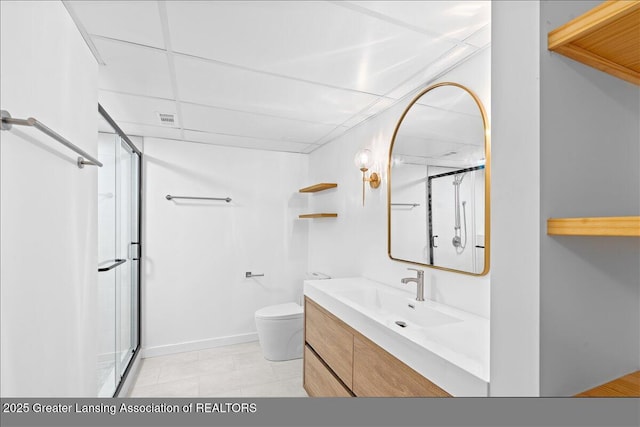 bathroom featuring vanity, baseboards, an enclosed shower, a paneled ceiling, and toilet