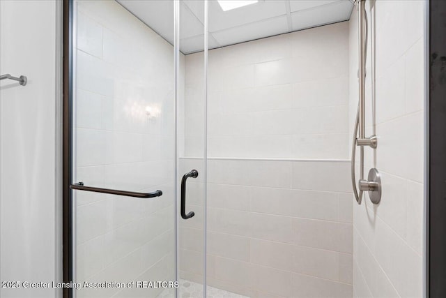 full bath with a shower stall and a paneled ceiling