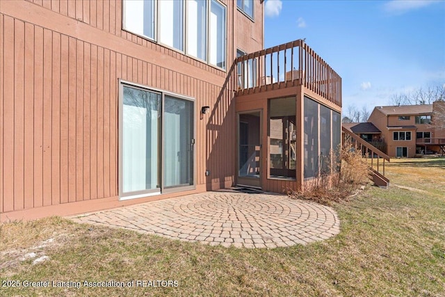 rear view of house featuring a yard, a sunroom, and a patio area