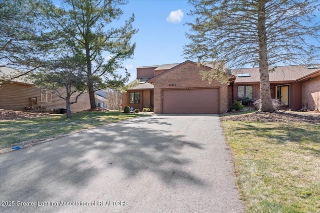 view of front facade featuring a front lawn, an attached garage, brick siding, and driveway