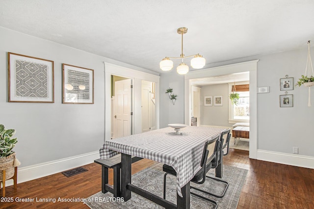 dining room featuring visible vents, baseboards, and dark wood-style flooring